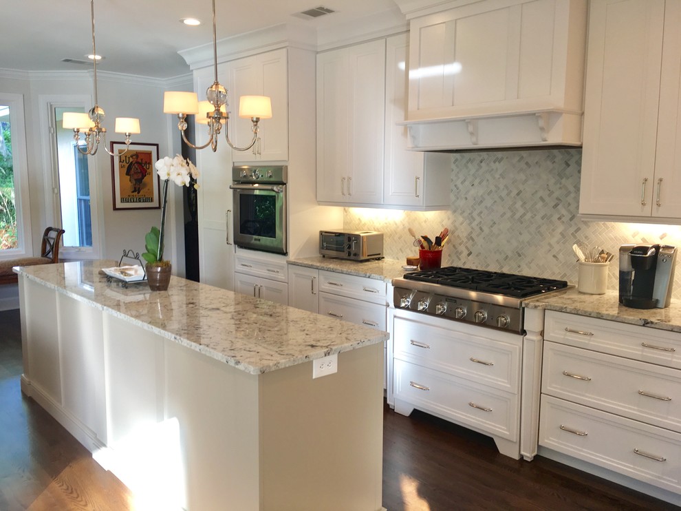 Large transitional u-shaped dark wood floor and brown floor eat-in kitchen photo with a farmhouse sink, recessed-panel cabinets, beige cabinets, granite countertops, white backsplash, marble backsplash, stainless steel appliances and an island