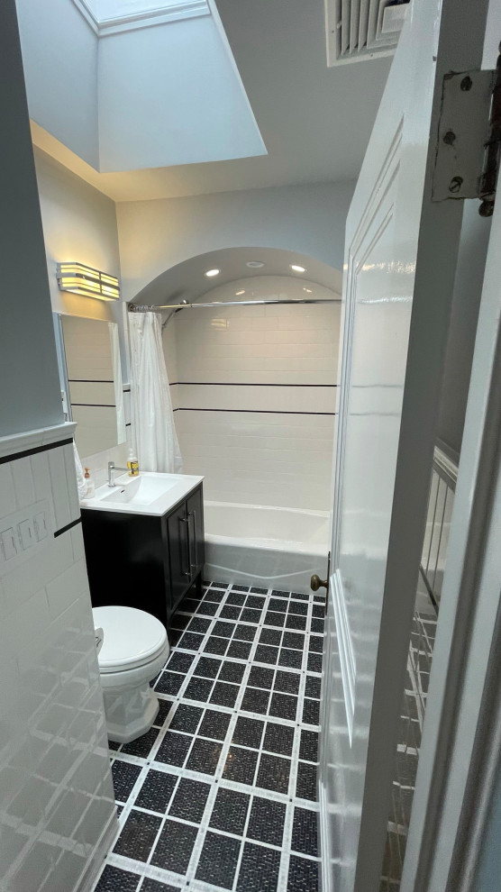 Idée de décoration pour une petite salle de bain tradition avec un placard à porte plane, des portes de placard noires, une baignoire en alcôve, un combiné douche/baignoire, WC séparés, un carrelage blanc, des carreaux de porcelaine, un mur bleu, un sol en marbre, un lavabo intégré, un plan de toilette en surface solide, un sol noir, une cabine de douche avec un rideau, un plan de toilette blanc, une niche, meuble simple vasque, meuble-lavabo sur pied, un plafond voûté et boiseries.