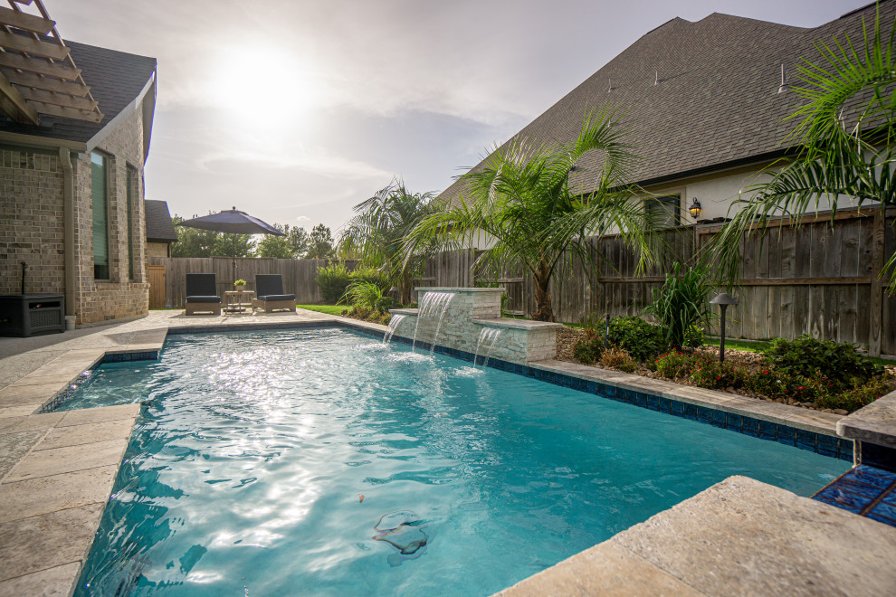 Immagine di una piscina minimalista rettangolare di medie dimensioni e dietro casa con pedane