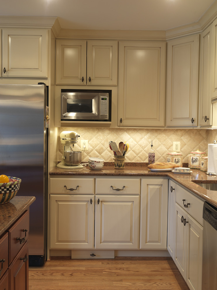 Inspiration for a traditional kitchen in DC Metro with stainless steel appliances, quartz benchtops, an undermount sink, raised-panel cabinets, beige cabinets, beige splashback and stone tile splashback.