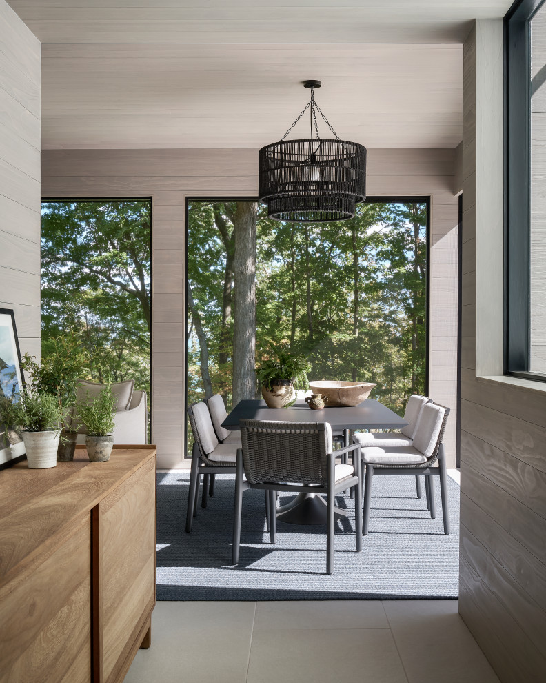 This is an example of a mid-sized contemporary tile screened-in back porch design in Chicago with a roof extension.
