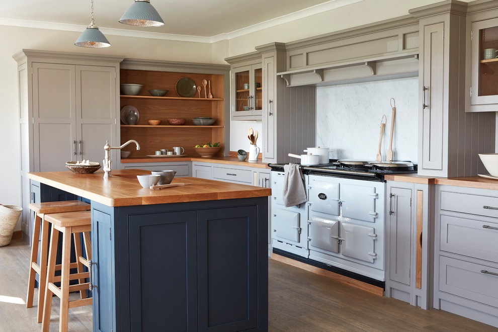Large country l-shaped separate kitchen in London with an integrated sink, shaker cabinets, grey cabinets, wood benchtops, white splashback, coloured appliances, light hardwood floors and with island.
