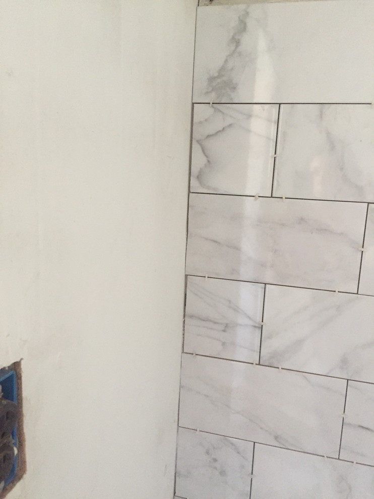 Grout or caulk where tile meets wall?