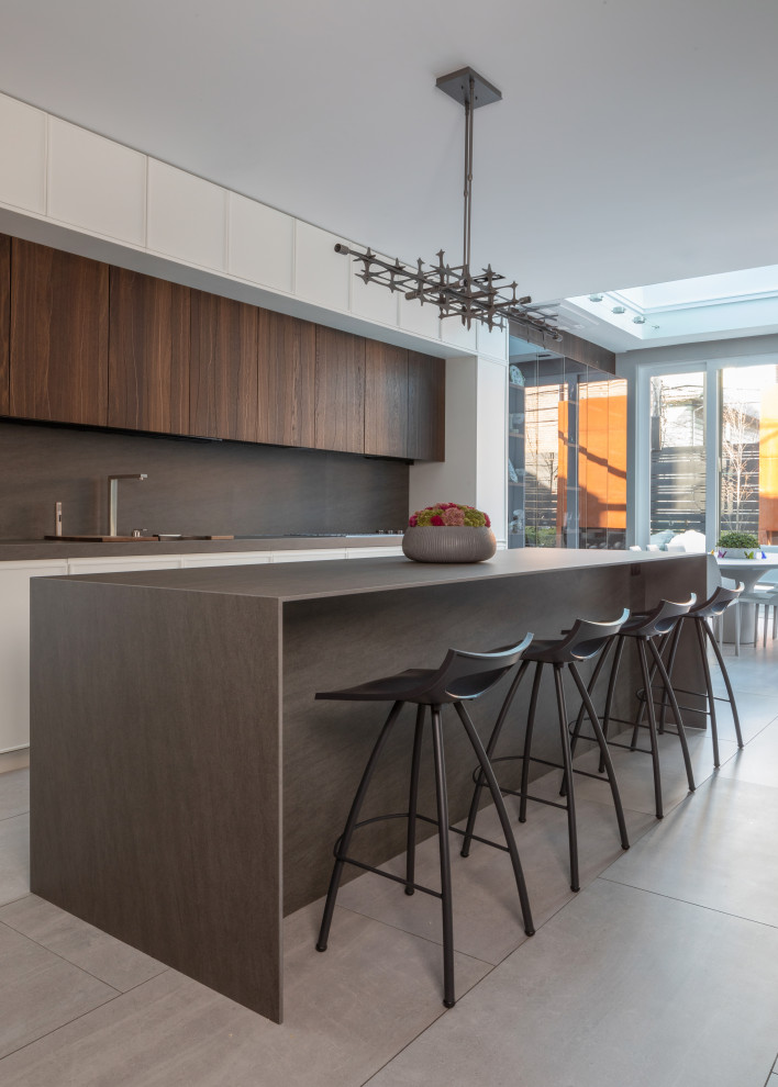 Foto di un'ampia cucina minimalista con lavello sottopiano, paraspruzzi grigio, elettrodomestici da incasso, pavimento in gres porcellanato, pavimento grigio e top grigio