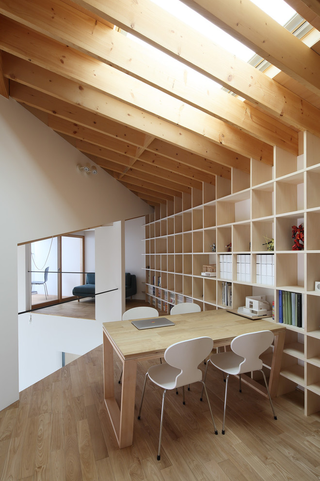 This is an example of a modern home office in Kyoto with white walls, medium hardwood floors and brown floor.