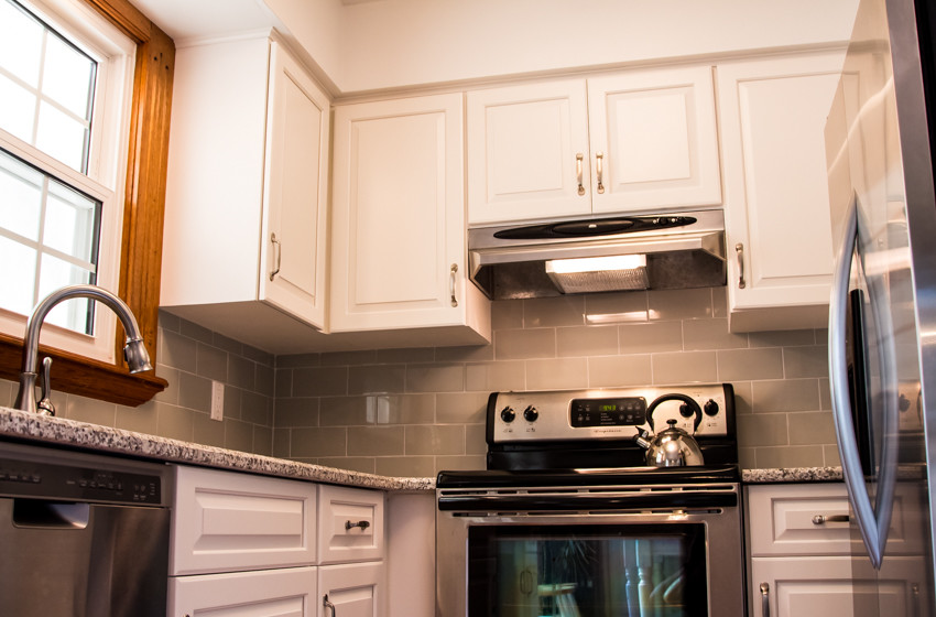 Small transitional u-shaped light wood floor kitchen photo in Baltimore with an undermount sink, raised-panel cabinets, white cabinets and no island