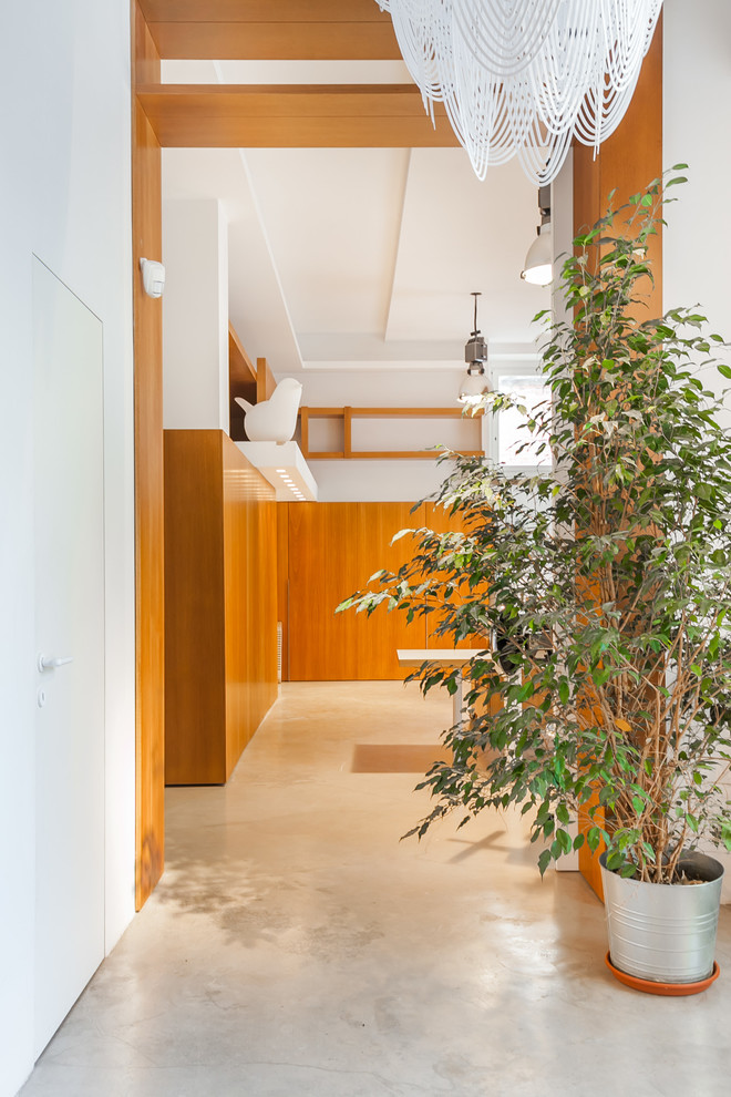 Photo of a mid-sized contemporary hallway in Rome with white walls and concrete floors.
