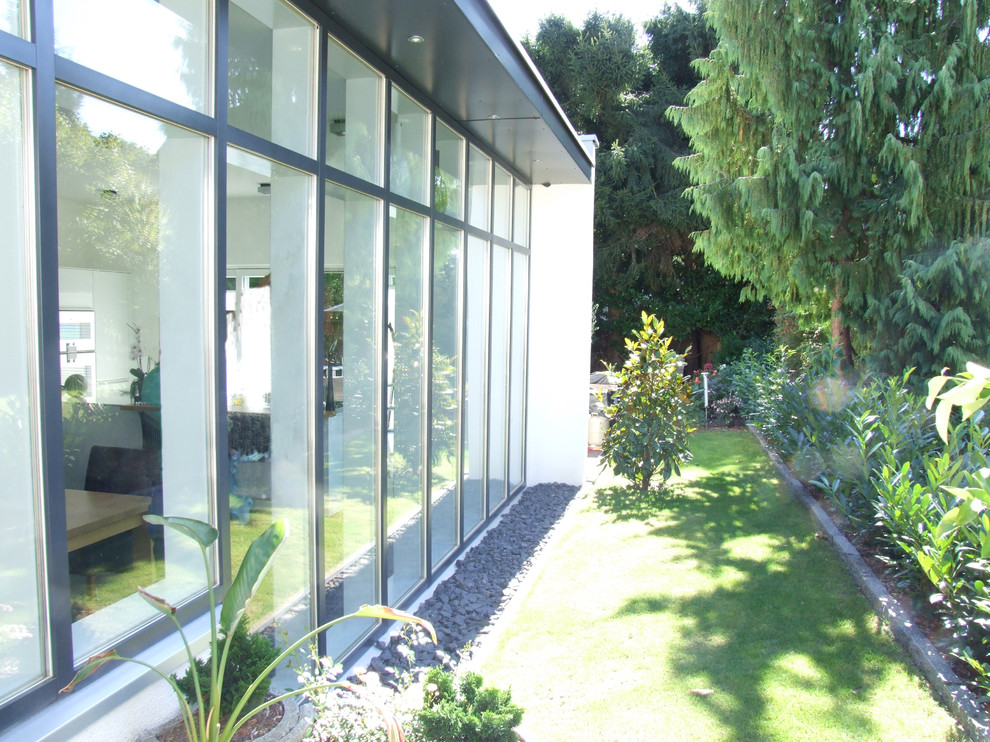 Contemporary glass white duplex exterior in Essen with a flat roof.