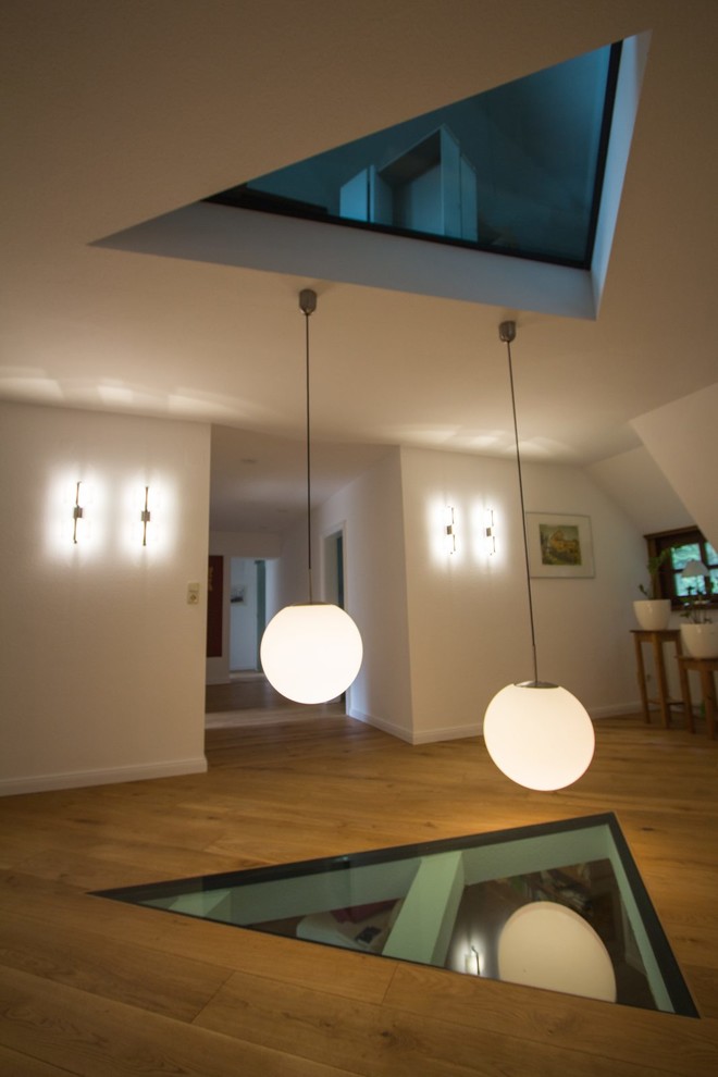 Geräumiger Rustikaler Flur mit weißer Wandfarbe, hellem Holzboden und braunem Boden in Hamburg