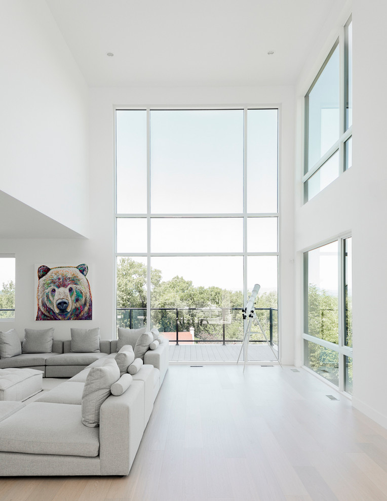 Photo of a contemporary open concept living room in Montreal with a music area, white walls, light hardwood floors, no tv and beige floor.
