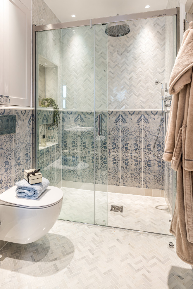 Пример оригинального дизайна: большая главная, серо-белая ванная комната в средиземноморском стиле с фасадами в стиле шейкер, бежевыми фасадами, отдельно стоящей ванной, открытым душем, инсталляцией, синей плиткой, керамогранитной плиткой, серыми стенами, мраморным полом, монолитной раковиной, мраморной столешницей, серым полом, серой столешницей, тумбой под одну раковину и напольной тумбой