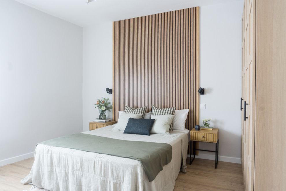 This is an example of a mid-sized contemporary master bedroom in Madrid with grey walls, medium hardwood floors, brown floor and wood walls.