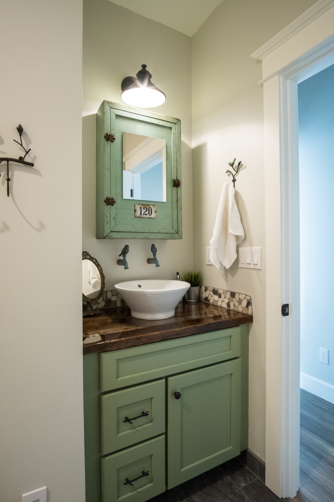 Inspiration for a small traditional 3/4 bathroom in Portland with shaker cabinets, green cabinets, multi-coloured tile, stone tile, white walls, a vessel sink, wood benchtops and brown benchtops.