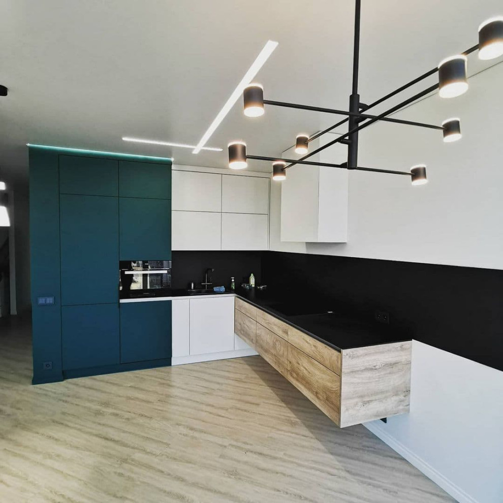 Photo of a large modern l-shaped open plan kitchen in Moscow with a drop-in sink, flat-panel cabinets, green cabinets, solid surface benchtops, black splashback, porcelain splashback, black appliances, medium hardwood floors, no island, brown floor and grey benchtop.