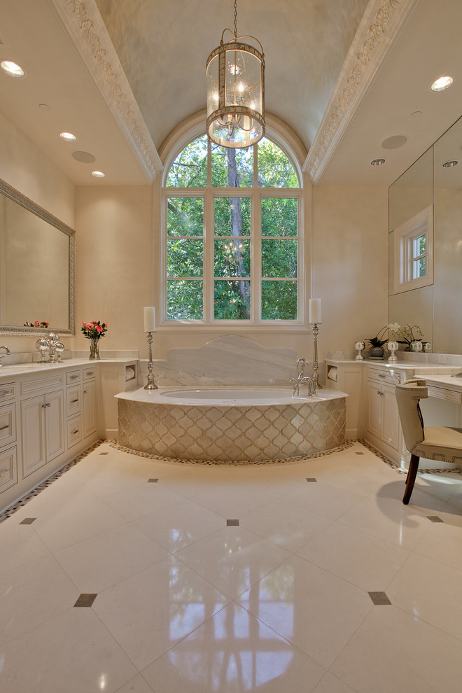 Large mediterranean master bathroom in Dallas with beaded inset cabinets, white cabinets, an undermount tub, limestone floors, an undermount sink, marble benchtops, white floor and white benchtops.