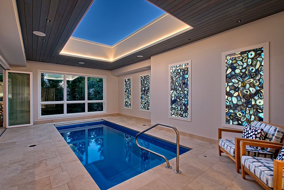 Inspiration for a mid-sized contemporary indoor rectangular lap pool in Chicago with natural stone pavers and a pool house.