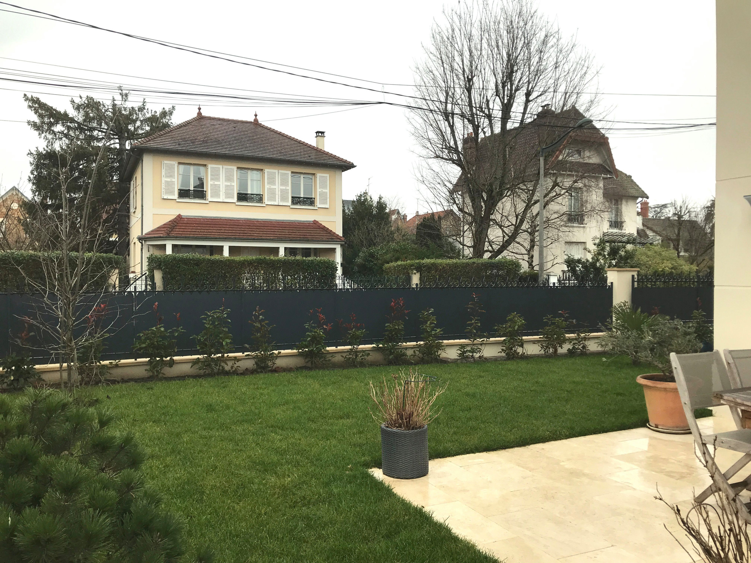 Aménagement du jardin avec des palissades en bois et des arbres palissés.