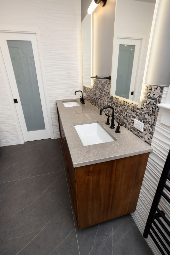 Idéer för att renovera ett stort funkis grå grått en-suite badrum, med skåp i mellenmörkt trä, ett fristående badkar, grå kakel, keramikplattor, bänkskiva i kvarts och svart golv
