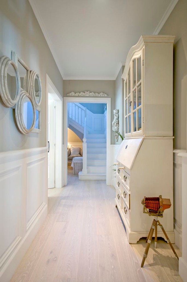 Mid-sized transitional hallway in Madrid with grey walls and light hardwood floors.