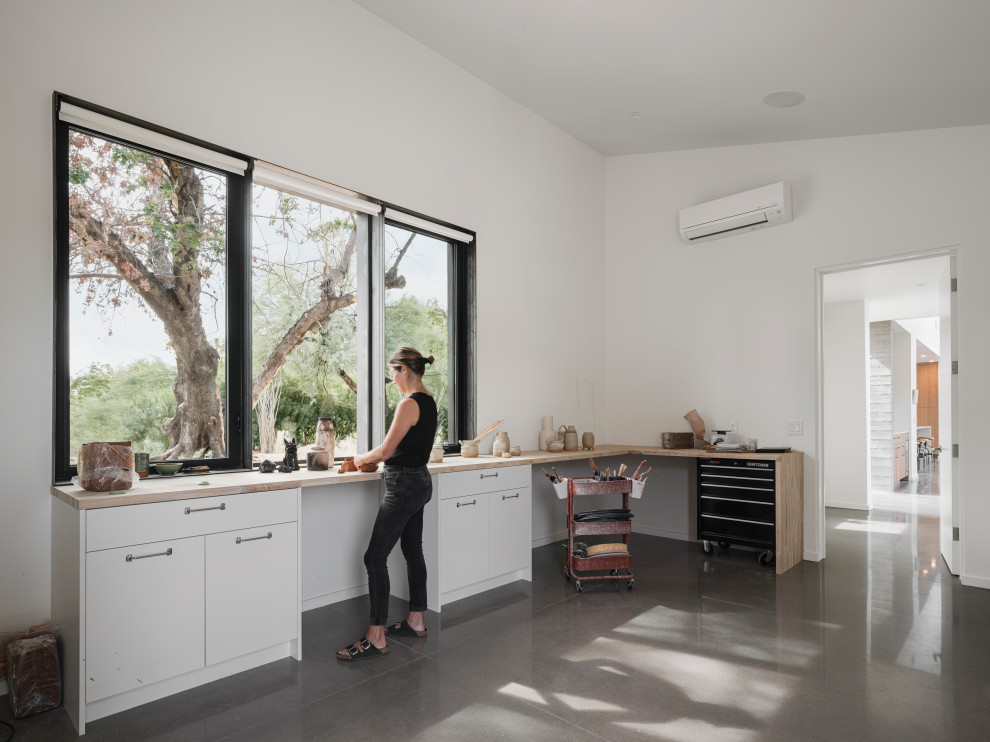 Стильный дизайн: кабинет в стиле модернизм с бетонным полом и отдельно стоящим рабочим столом - последний тренд