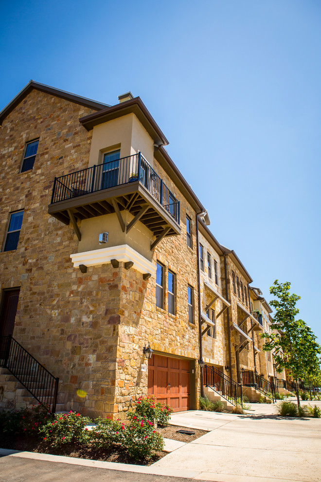 Example of a huge transitional beige three-story stone exterior home design in Austin with a hip roof