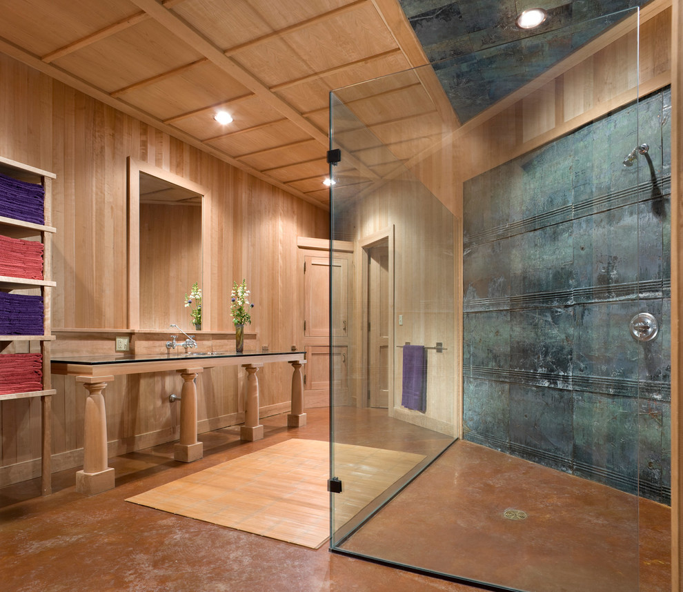 This is an example of a small transitional master bathroom in New York with open cabinets, light wood cabinets, a curbless shower, metal tile, concrete floors, an undermount sink, glass benchtops, an open shower, brown walls and brown floor.