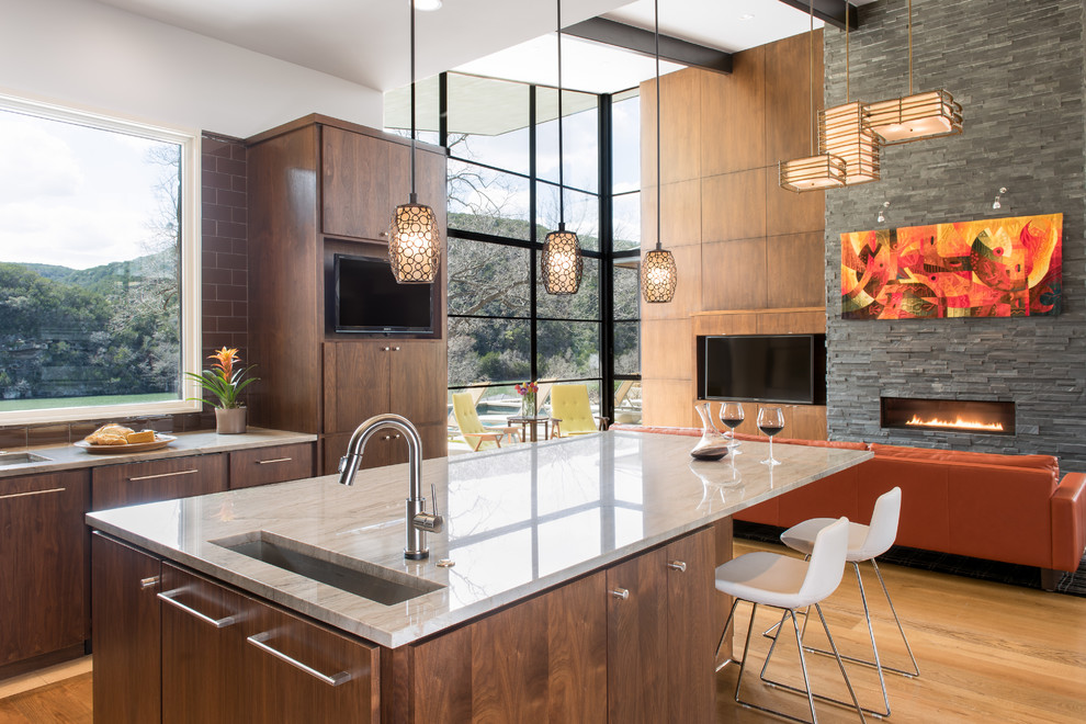 This is an example of a large contemporary eat-in kitchen in Austin with an undermount sink, flat-panel cabinets, brown splashback, subway tile splashback, with island, medium wood cabinets, quartzite benchtops, medium hardwood floors, stainless steel appliances and brown floor.