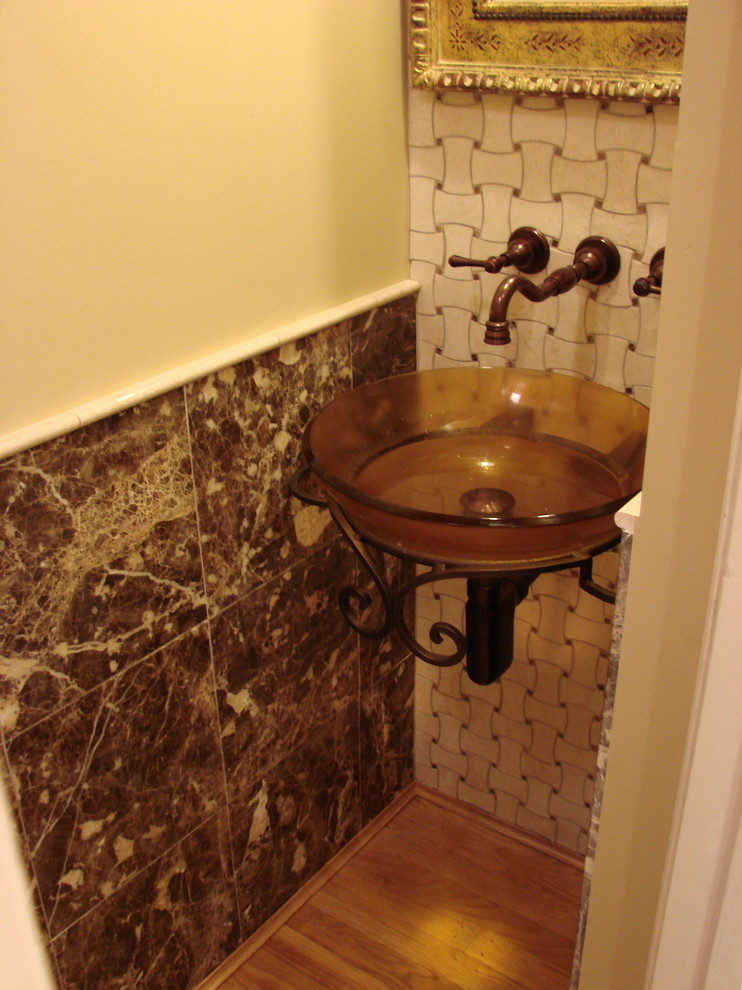 Inspiration for a small mediterranean powder room in Cincinnati with multi-coloured tile, white tile, ceramic tile, yellow walls, medium hardwood floors and a vessel sink.