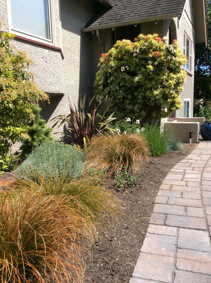 Design ideas for a mid-sized arts and crafts front yard full sun xeriscape in Vancouver with a garden path and concrete pavers.