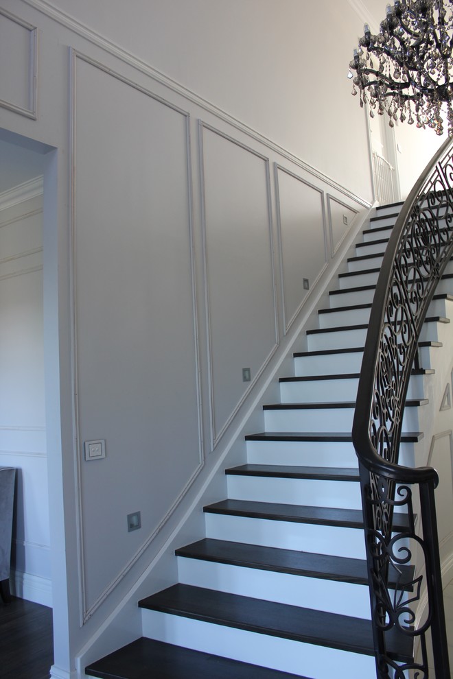 This is an example of a large traditional wood curved staircase in Melbourne with painted wood risers.