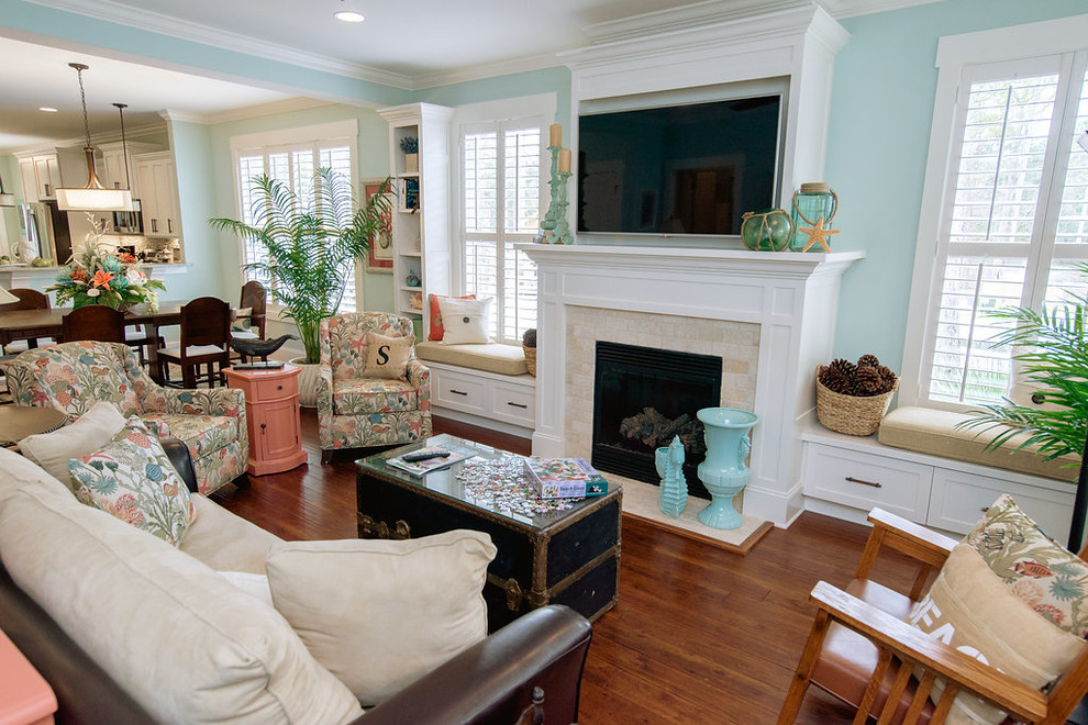 Photo of a mid-sized country open concept living room in Wilmington with blue walls, medium hardwood floors, a standard fireplace, a tile fireplace surround and a built-in media wall.