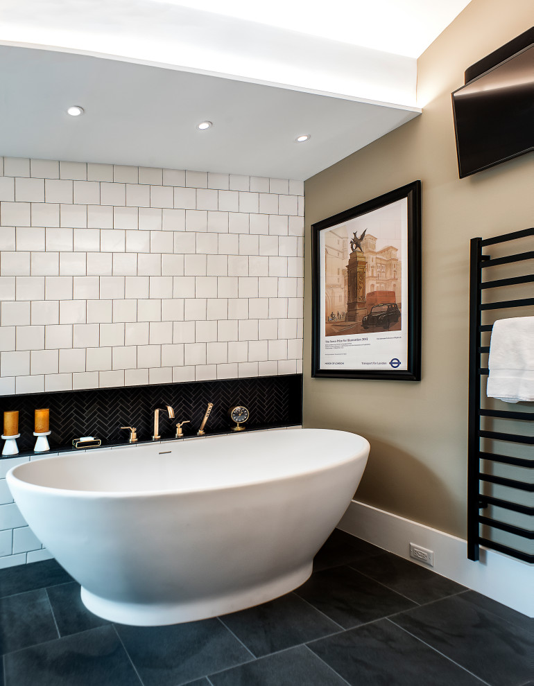 Photo of a large contemporary ensuite bathroom in Richmond with flat-panel cabinets, light wood cabinets, a freestanding bath, a double shower, a two-piece toilet, beige tiles, metro tiles, beige walls, slate flooring, a submerged sink, soapstone worktops, black floors, a hinged door, grey worktops, a wall niche, double sinks, a floating vanity unit and a vaulted ceiling.