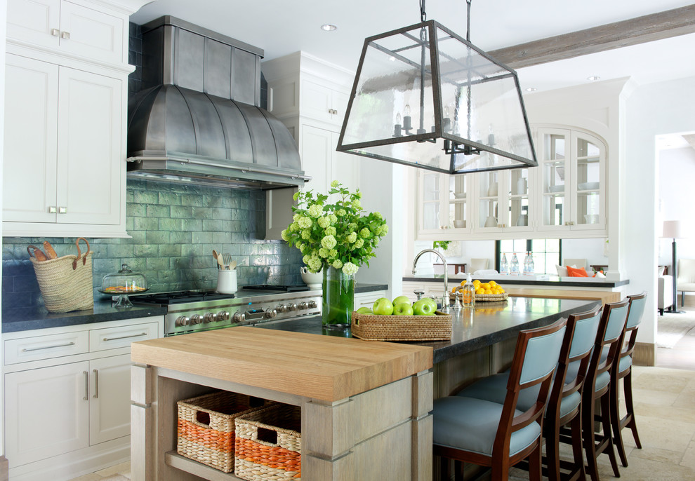 Kitchen - transitional kitchen idea in New York with recessed-panel cabinets, white cabinets, metallic backsplash, subway tile backsplash, stainless steel appliances and an island