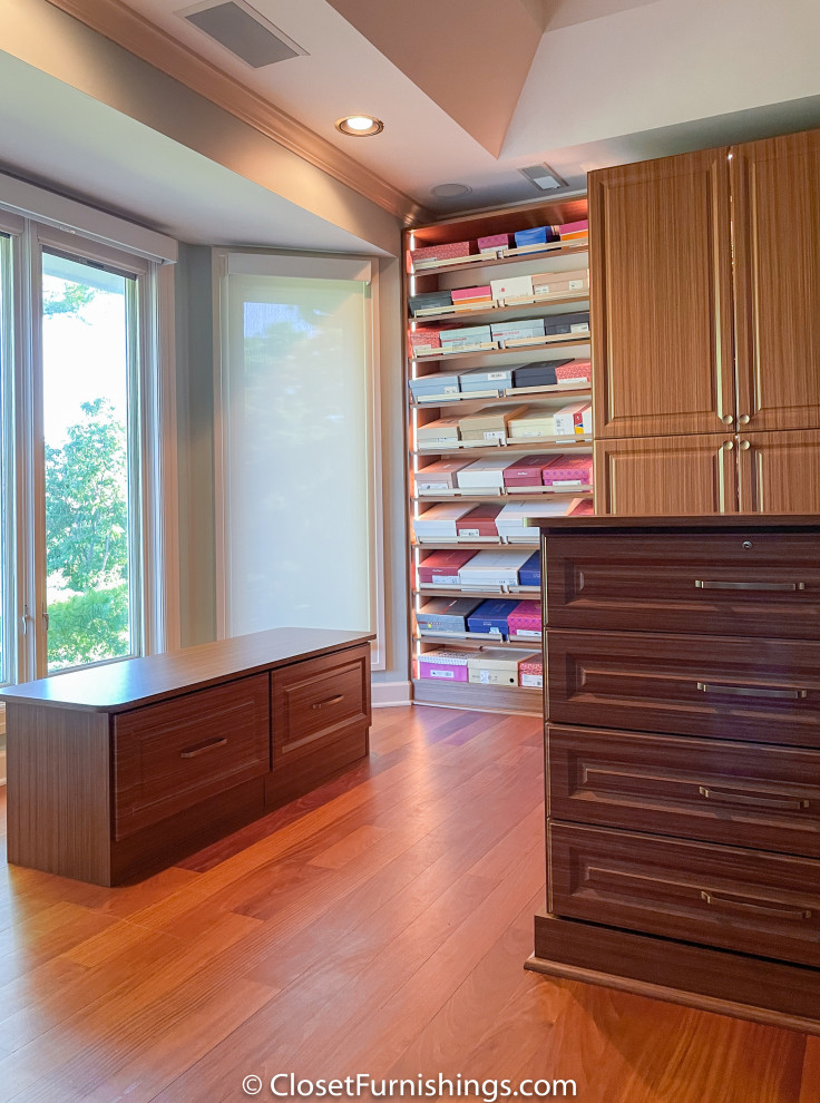 Large traditional women's walk-in wardrobe in Chicago with raised-panel cabinets and brown cabinets.