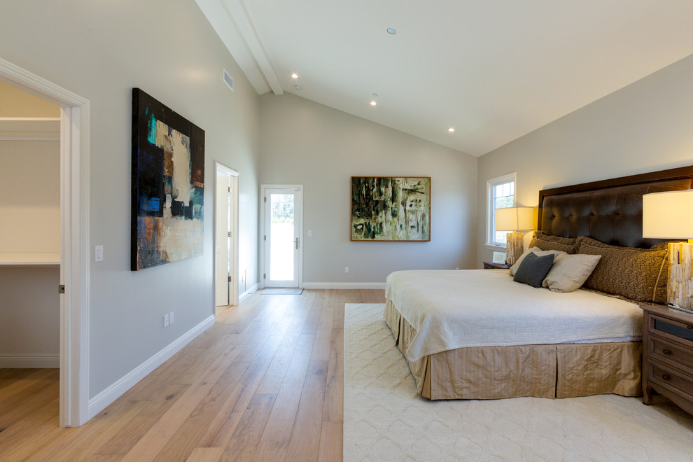Design ideas for a large transitional master bedroom in Los Angeles with white walls, light hardwood floors, no fireplace and brown floor.