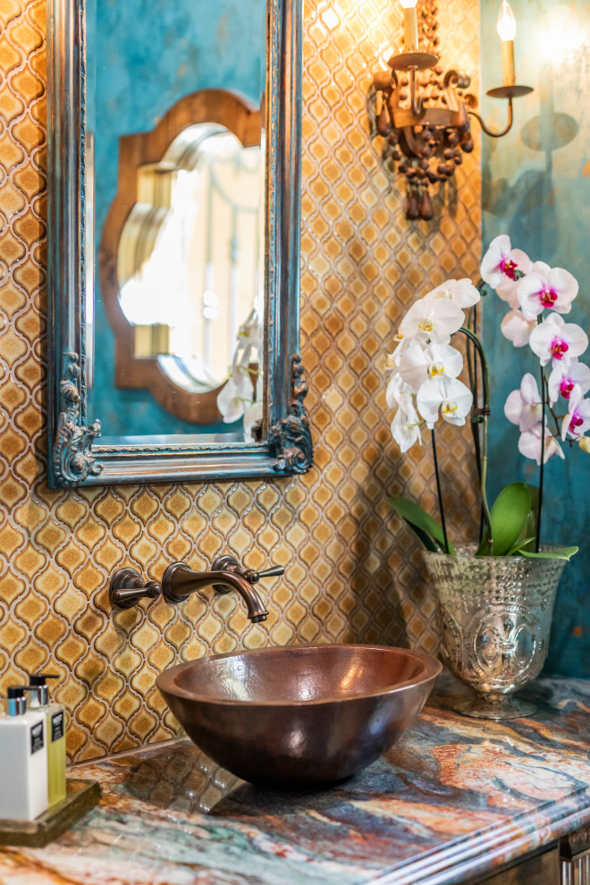 На фото: туалет среднего размера в стиле фьюжн с фасадами с выступающей филенкой, коричневыми фасадами, раздельным унитазом, желтой плиткой, керамогранитной плиткой, синими стенами, полом из травертина, настольной раковиной, столешницей из гранита, бежевым полом, разноцветной столешницей и встроенной тумбой с