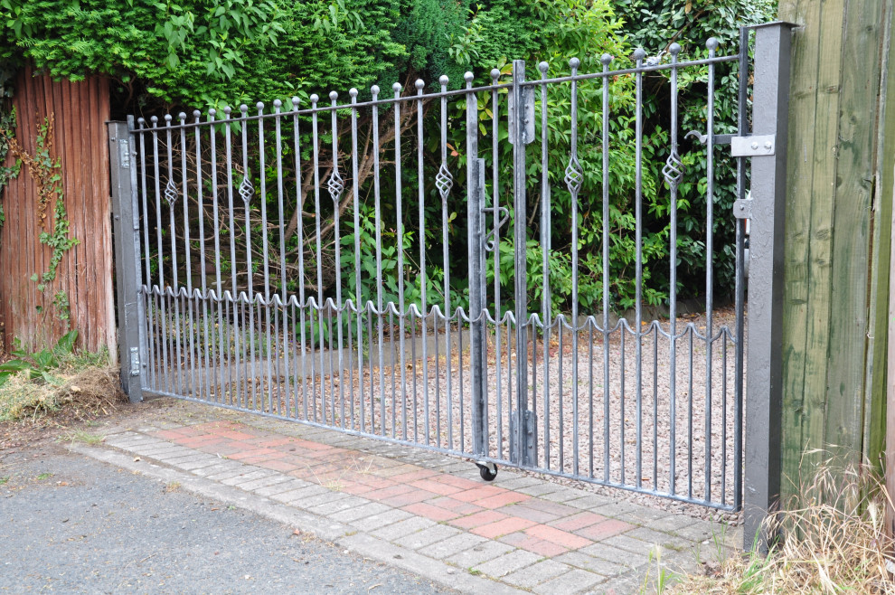 На фото: участок и сад в классическом стиле с с металлическим забором с