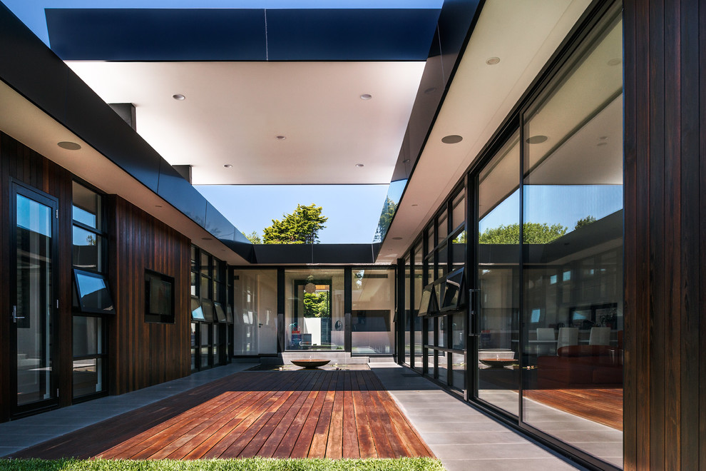 This is an example of a mid-sized midcentury courtyard shaded outdoor sport court for summer in Melbourne with decking.