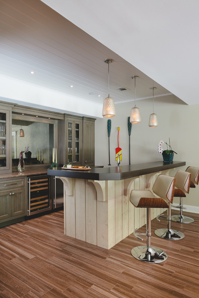 Design ideas for a beach style single-wall seated home bar in Atlanta with porcelain floors, recessed-panel cabinets, medium wood cabinets and wood benchtops.