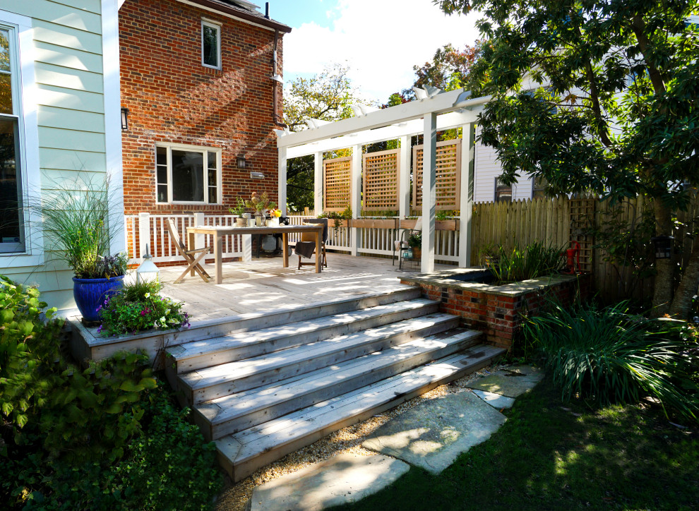Deck - mid-sized transitional backyard ground level privacy and mixed material railing deck idea in DC Metro with a pergola