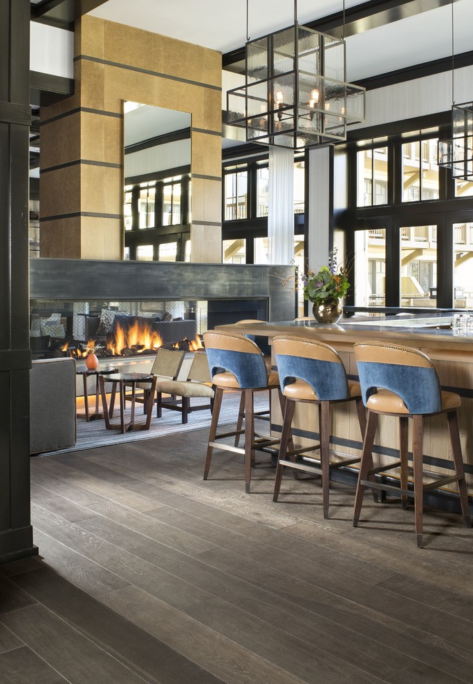This is an example of a large contemporary u-shaped seated home bar in Denver with light wood cabinets, wood benchtops and painted wood floors.