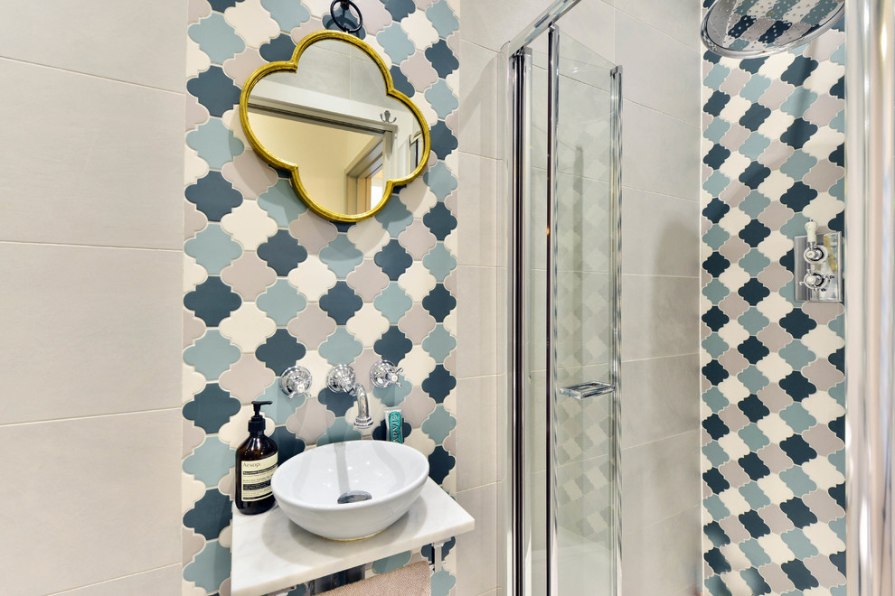 Small mediterranean 3/4 bathroom in London with an open shower, a hinged shower door, beige tile, blue tile, gray tile, white tile, beige walls and a vessel sink.