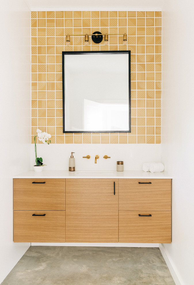 Bild på ett retro vit vitt badrum med dusch, med släta luckor, skåp i ljust trä, gul kakel, keramikplattor, vita väggar, betonggolv, ett undermonterad handfat och bänkskiva i kvarts