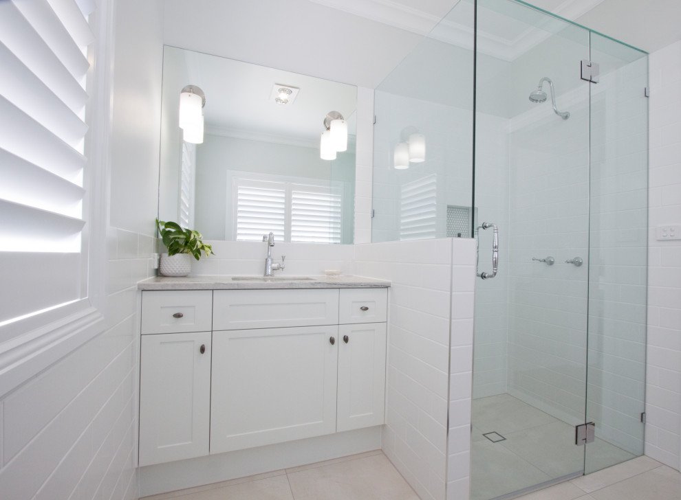 Design ideas for a small traditional bathroom in Sunshine Coast with shaker cabinets, white cabinets, white tile, subway tile, porcelain floors, an undermount sink, quartzite benchtops and a hinged shower door.
