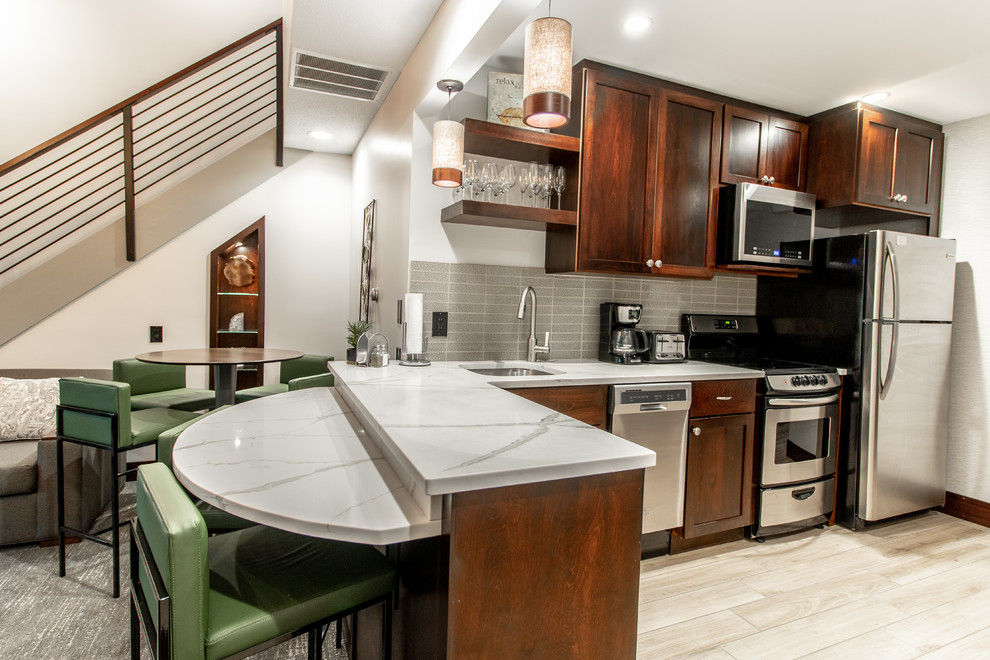 Mid-sized transitional l-shaped ceramic tile and beige floor open concept kitchen photo with an undermount sink, shaker cabinets, dark wood cabinets, quartz countertops, gray backsplash, ceramic backsplash, stainless steel appliances, no island and white countertops