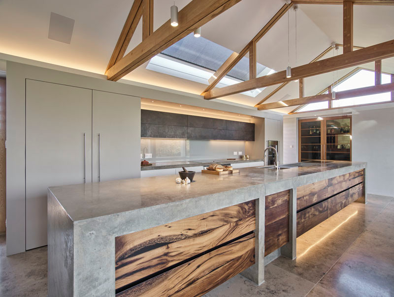 Design ideas for an expansive contemporary l-shaped eat-in kitchen in Cambridgeshire with an integrated sink, flat-panel cabinets, grey cabinets, concrete benchtops, grey splashback, glass sheet splashback, stainless steel appliances, porcelain floors, with island, multi-coloured floor and grey benchtop.