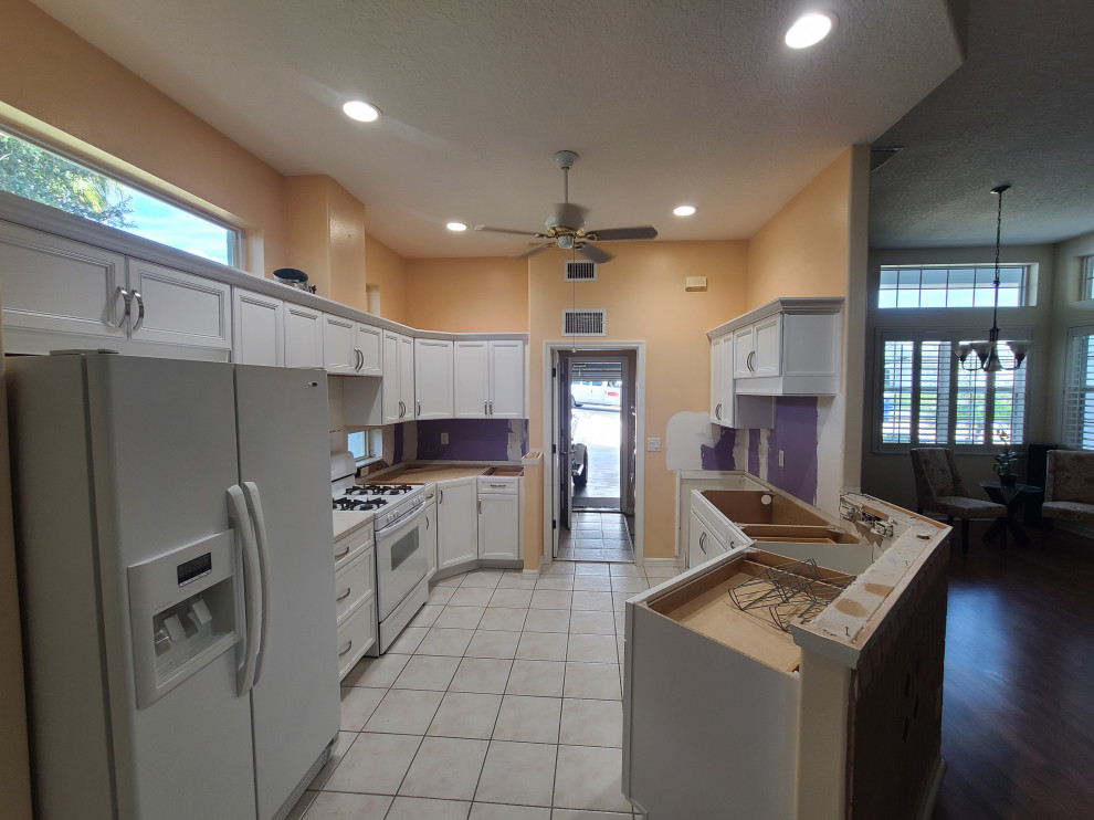 Eat-in kitchen - mid-sized u-shaped eat-in kitchen idea with flat-panel cabinets and white cabinets