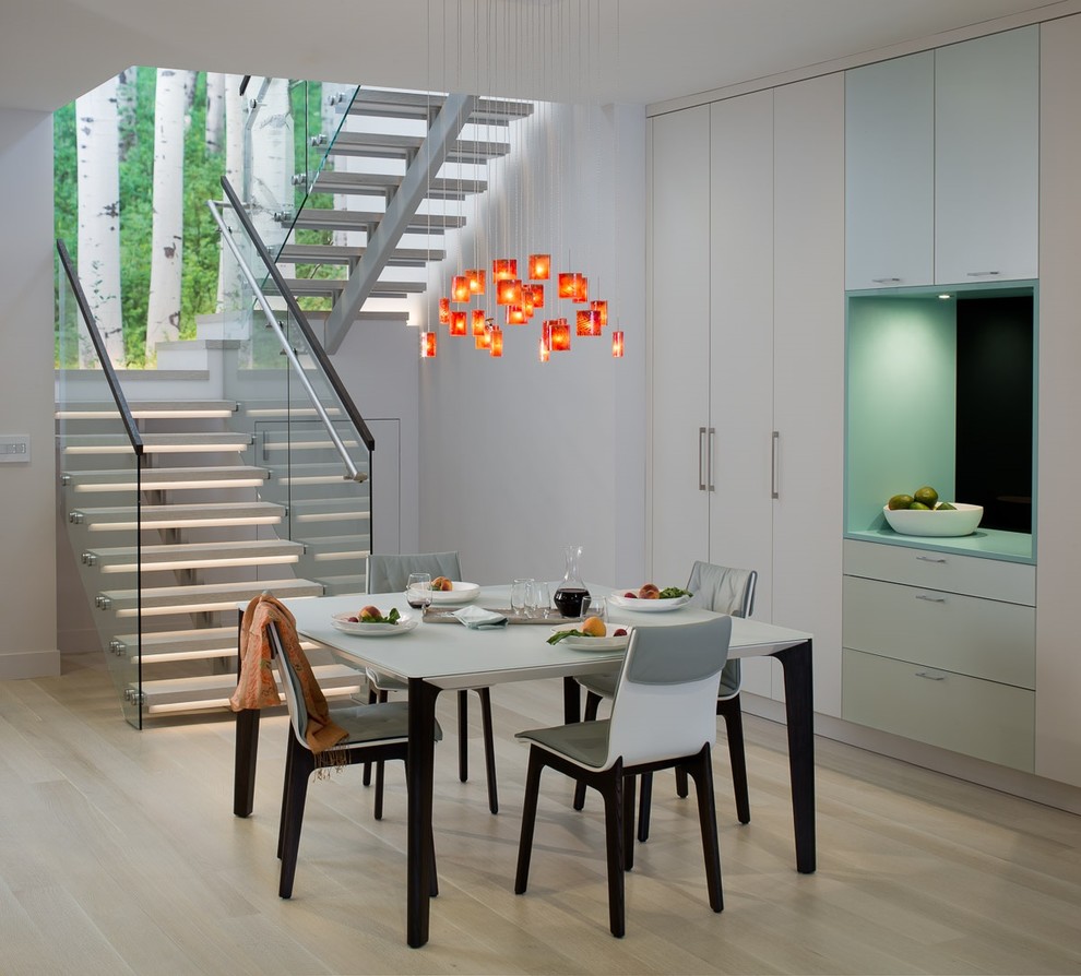 This is an example of a mid-sized contemporary dining room in San Francisco with light hardwood floors and white walls.