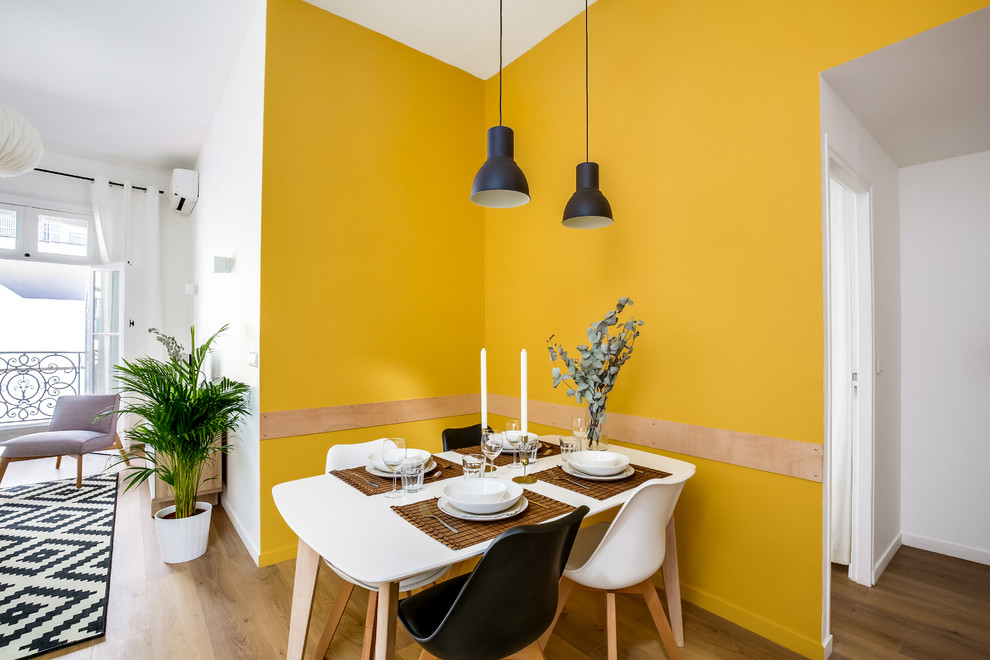 Large scandinavian dining room in Montpellier with yellow walls and vinyl floors.