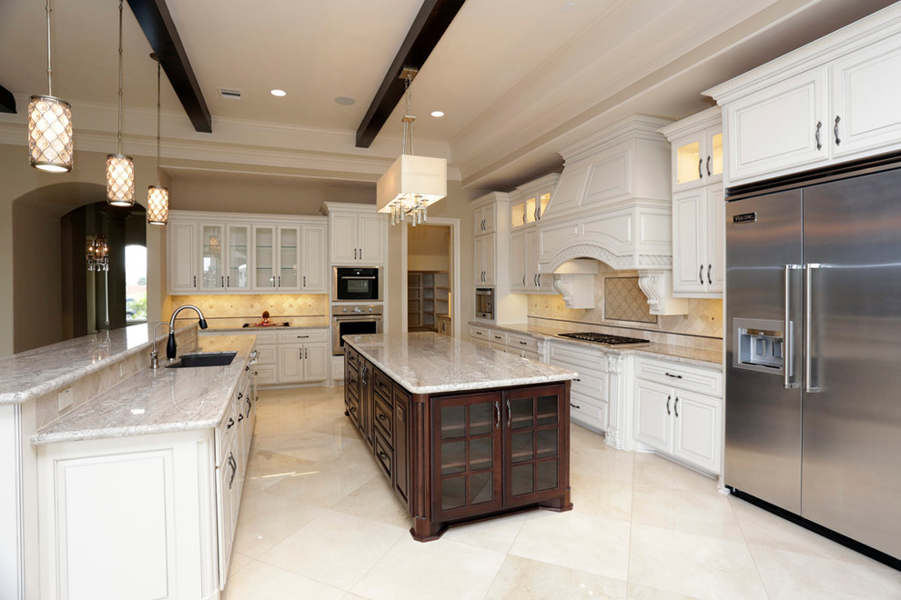 Example of a transitional marble floor eat-in kitchen design in Houston with an undermount sink, recessed-panel cabinets, white cabinets, granite countertops, stone tile backsplash, stainless steel appliances and two islands